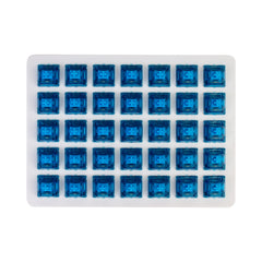 Gateron Blue Ink V2 clicky switches arranged in a tray showing the blue stems and transparent housings