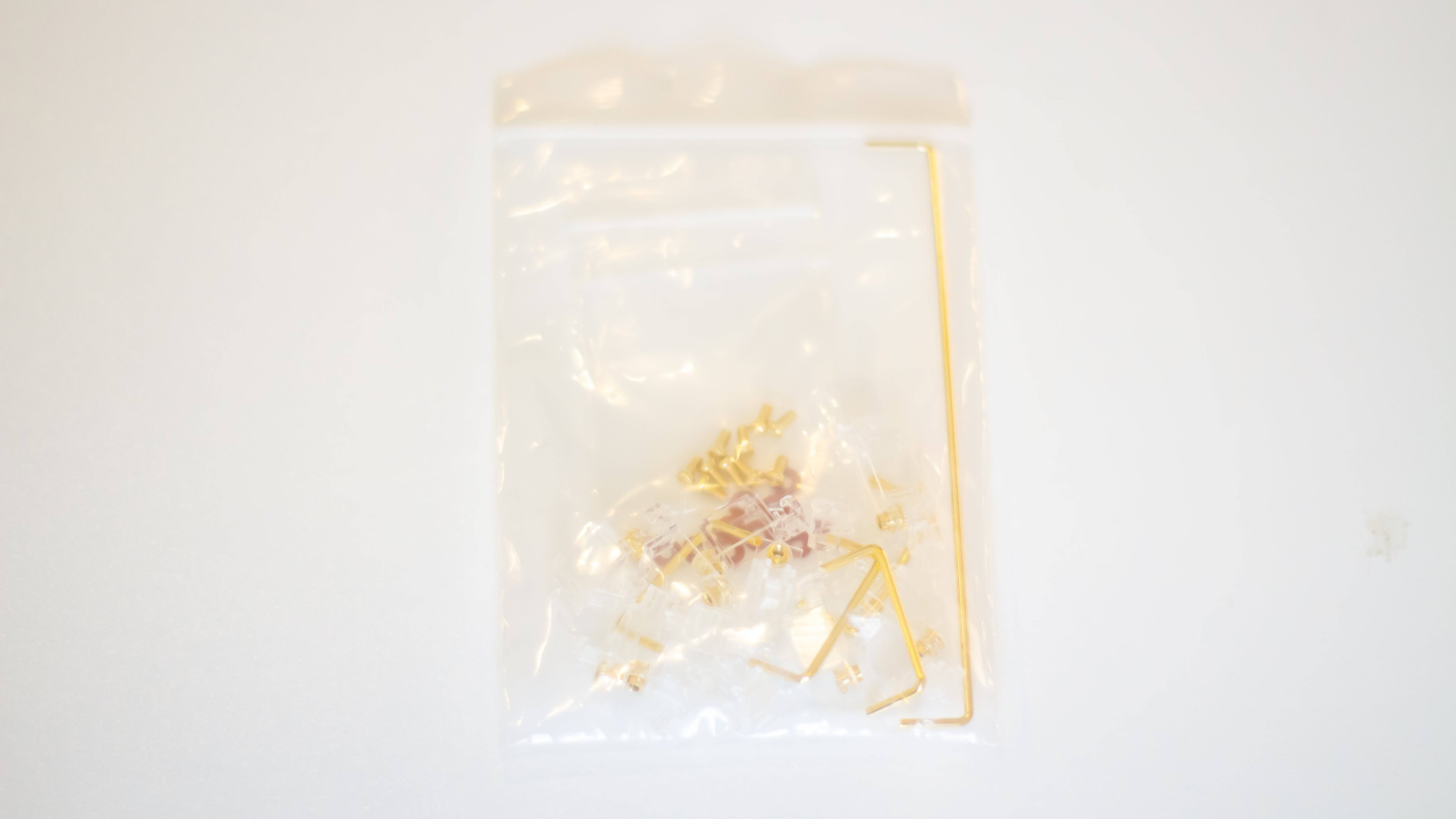 Bag of clear Durock V2 screw-in stabilizers with gold wires, gold screws, and red screw dampener pads for DIY custom mechanical keyboards.
