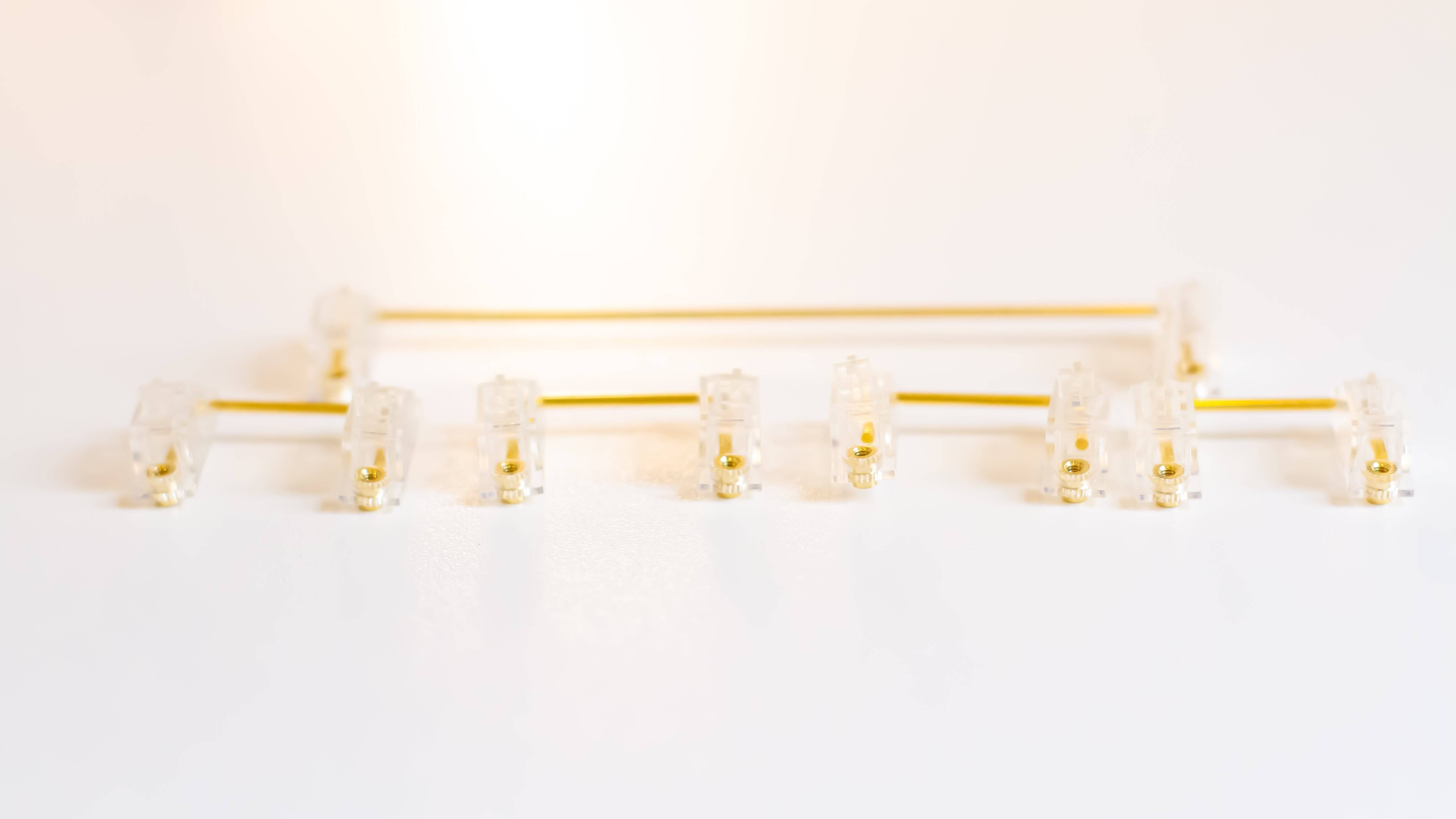 Clear Durock V2 stabilizers with gold wires for custom mechanical keyboards.