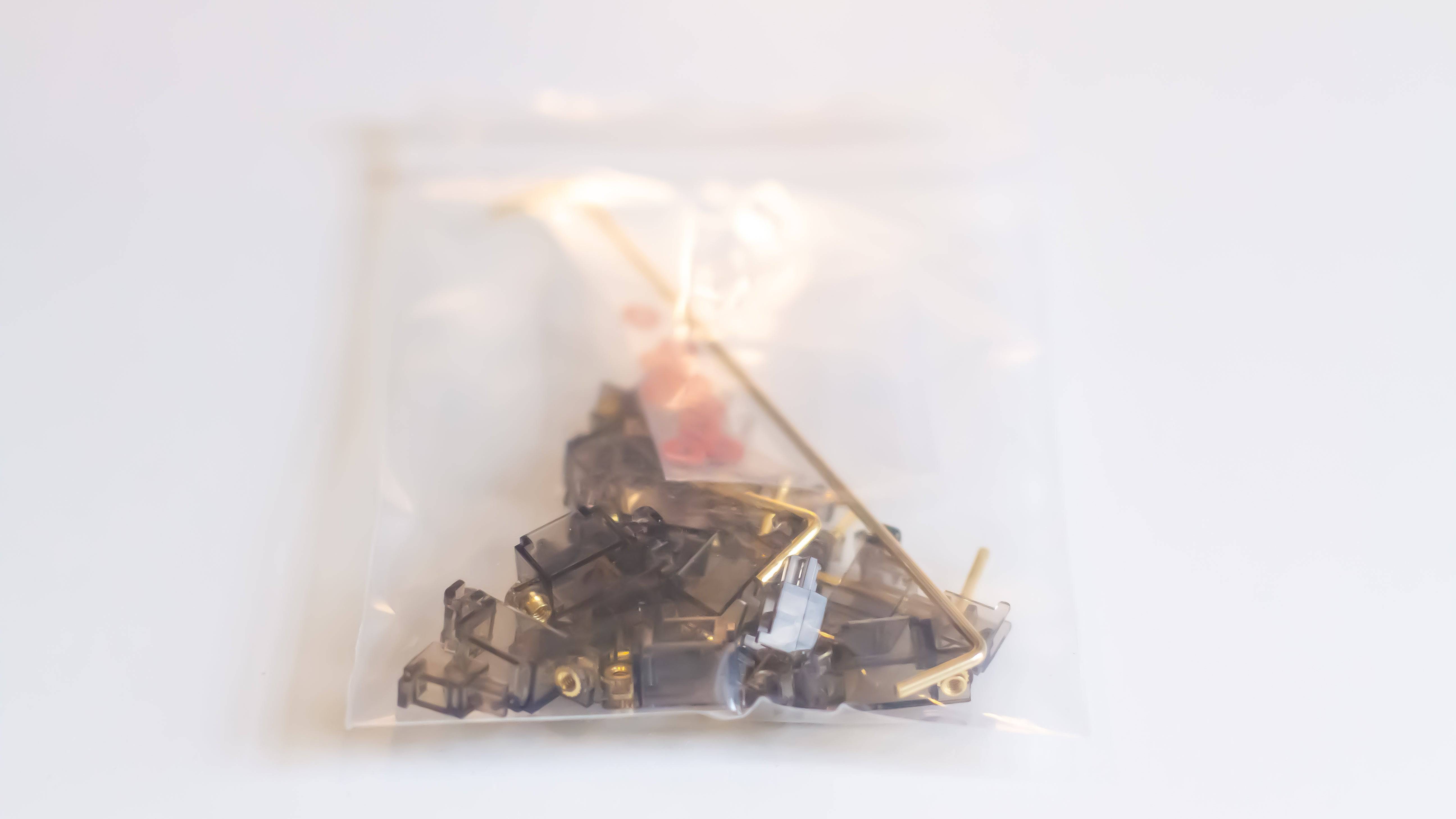 Bag of smokey black Durock V2 stabilizers with gold wires, screws, and screw washers for mechanical keyboards.