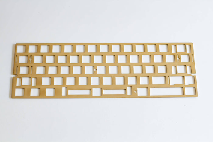 Angled top down view of the FB60/Freebird60 universal ANSI brass mechanical keyboard plate.